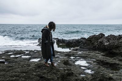 Full length of woman standing on beach against sky