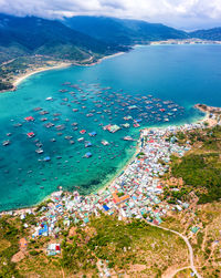 High angle view of townscape by sea against sky