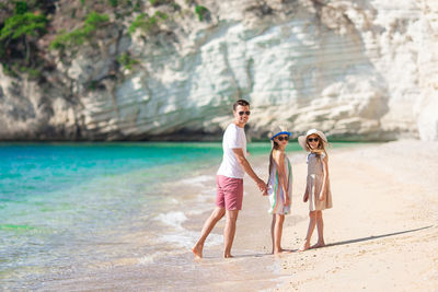 Full length of mother and daughter on beach