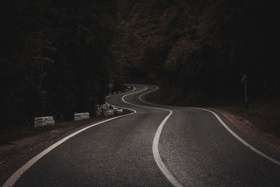 Empty road along trees