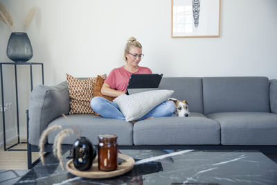 Woman on sofa using digital tablet