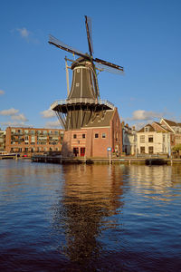 The famous adriaan windmill in haarlem on the river de spaarne on a clear day.