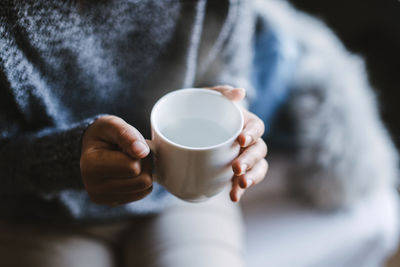 Midsection of woman holding coffee cup