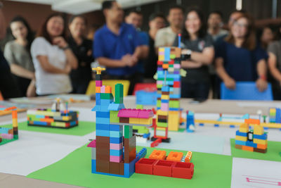 People standing in front of toy blocks on table