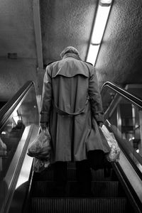 Rear view of man on escalator