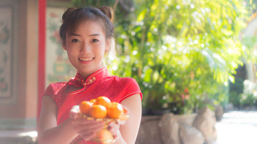 Portrait of smiling young woman holding apple