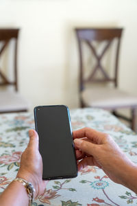 Midsection of person using mobile phone on table