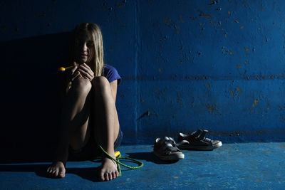 Young woman sitting on floor in darkroom
