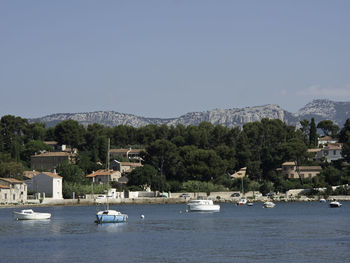 Boats in marina by sea against clear sky