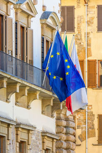 Low angle view of flags hanging on building