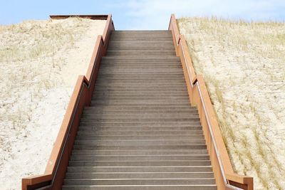 Low angle view of boardwalk on beach against sky