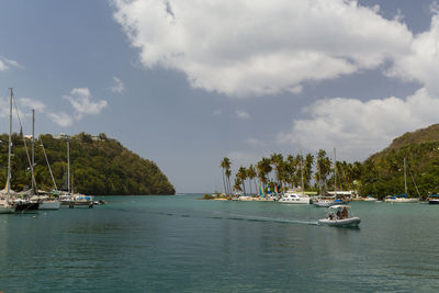 Sailboats in sea against sky