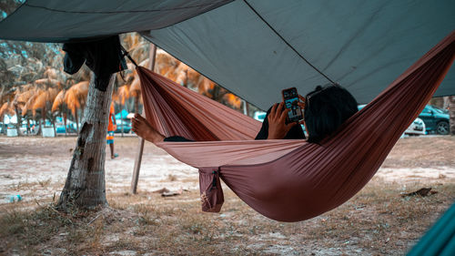 Rear view of woman sitting on hammock