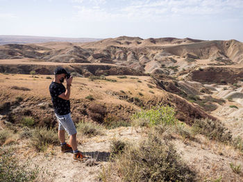 Rear view of woman walking on mountain against sky