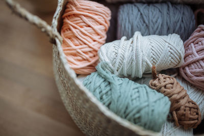 Beige wicker basket with multi-colored macrame threads