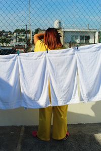 Rear view of woman standing by laundry