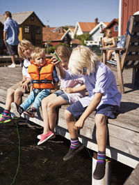 Children sitting on pier and fishing