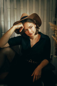 Young woman looking away while sitting at home