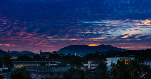 Silhouette buildings against sky at sunset