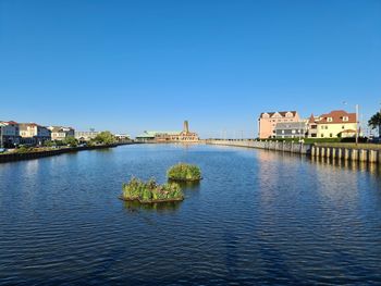 Bridge over river against clear blue sky