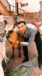 Portrait of smiling man with goat in village