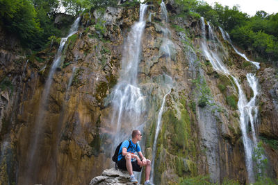 Full length of young man looking at waterfall