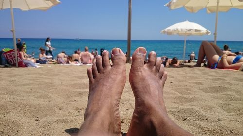 Low section of man relaxing on beach