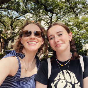 Portrait of smiling friends standing against trees