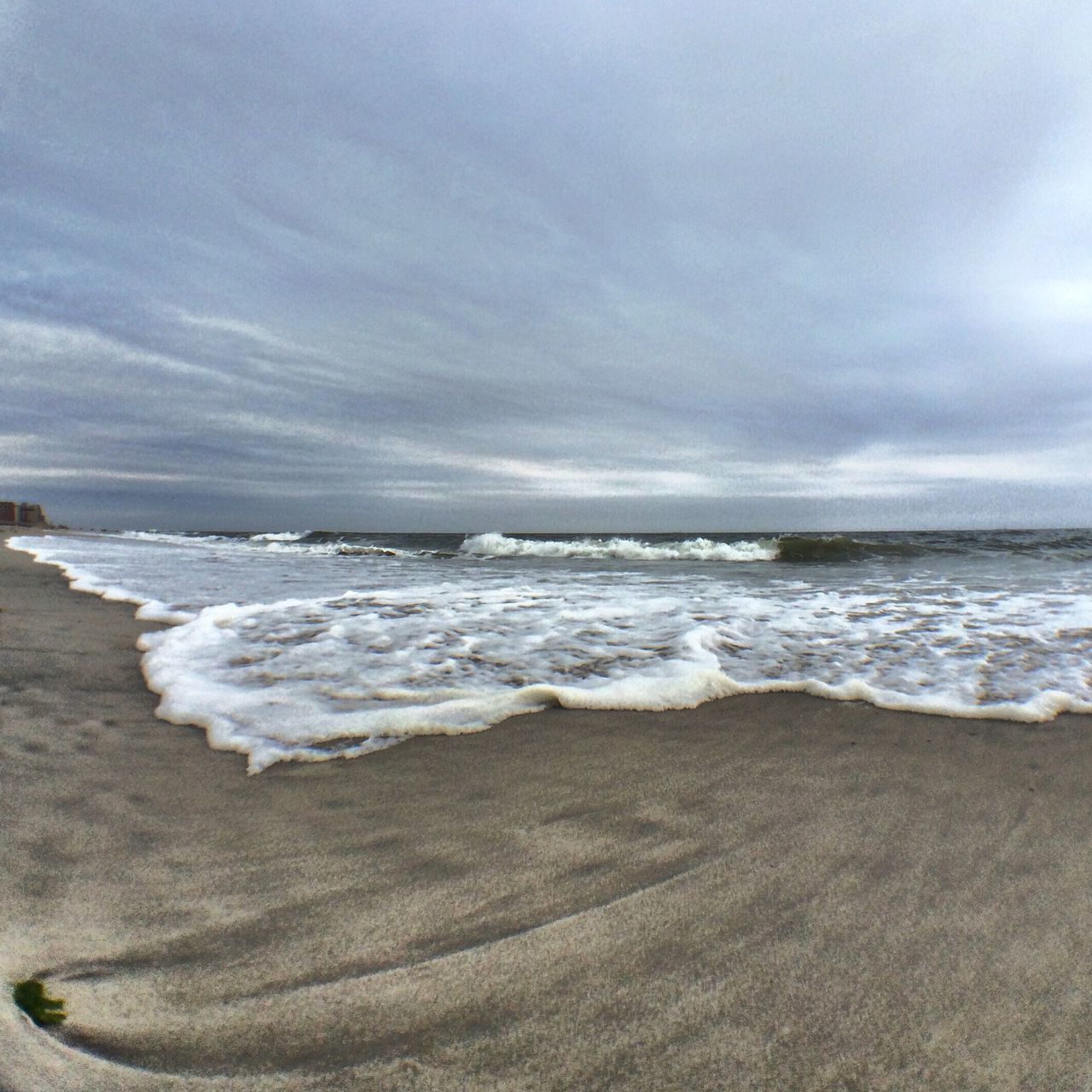 sea, beach, horizon over water, water, shore, sky, sand, wave, scenics, tranquil scene, tranquility, beauty in nature, surf, cloud - sky, nature, cloudy, idyllic, coastline, remote, outdoors