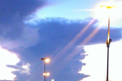 Low angle view of illuminated street light against sky