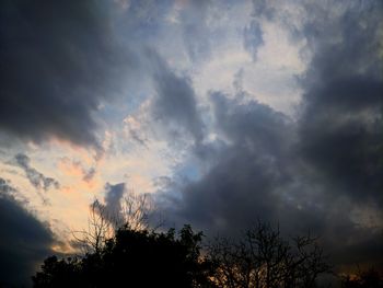 Low angle view of silhouette trees against dramatic sky