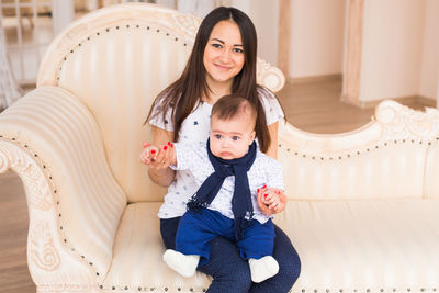 Portrait of young woman sitting on sofa at home