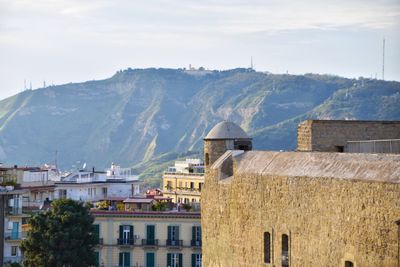 Buildings in town against cloudy sky