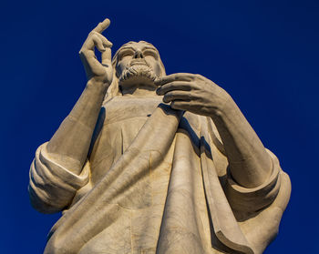 Low angle view of statue against blue sky