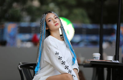 Portrait of young woman sitting at outdoor cafe