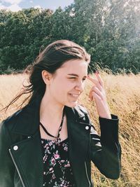 Young man holding camera while standing on field