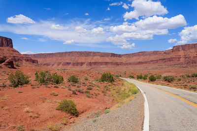 Road leading towards mountains against sky