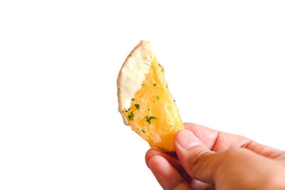 Close-up of hand holding ice cream over white background