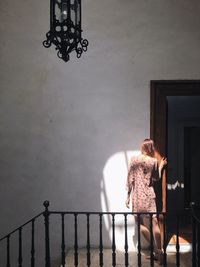 Rear view of woman standing by railing