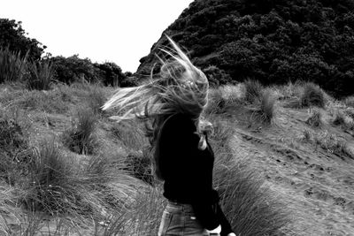 Woman looking at camera against sky