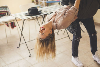 Low section of man holding happy girlfriend