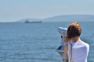 Rear view of woman looking at sea against sky