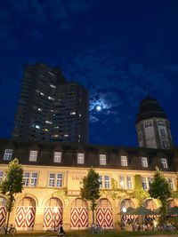 Low angle view of illuminated buildings against sky at night