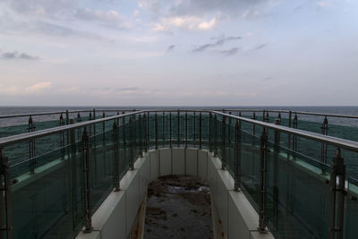 Bridge over sea against sky during sunset