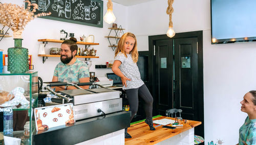 Full length of girl dancing on table at cafe