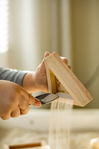 Close-up of hand holding wood at home
