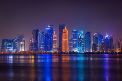 Coloful illuminated skyline of doha at night, qatar, middle east against dark sky