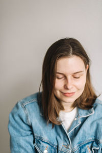 Portrait of beautiful young woman against wall