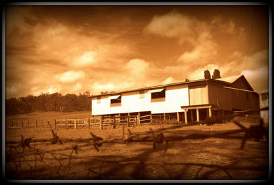 House on field against sky during sunset