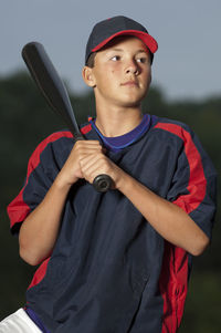 Portrait of a baseball player holding his bat wearing a warm up jacket